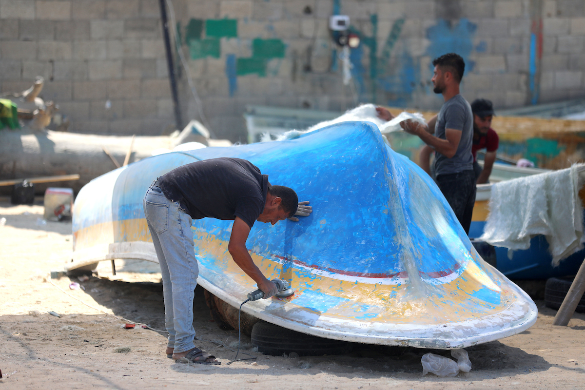 Palestinian maintain and repair the fishing boats using fiberglass material at the Gaza seaport on September 12 2023. The boats began piling up in Gaza 15 years ago after Israel imposed a land air and sea blockade on the small Palestinian coastal enclave in 2007.